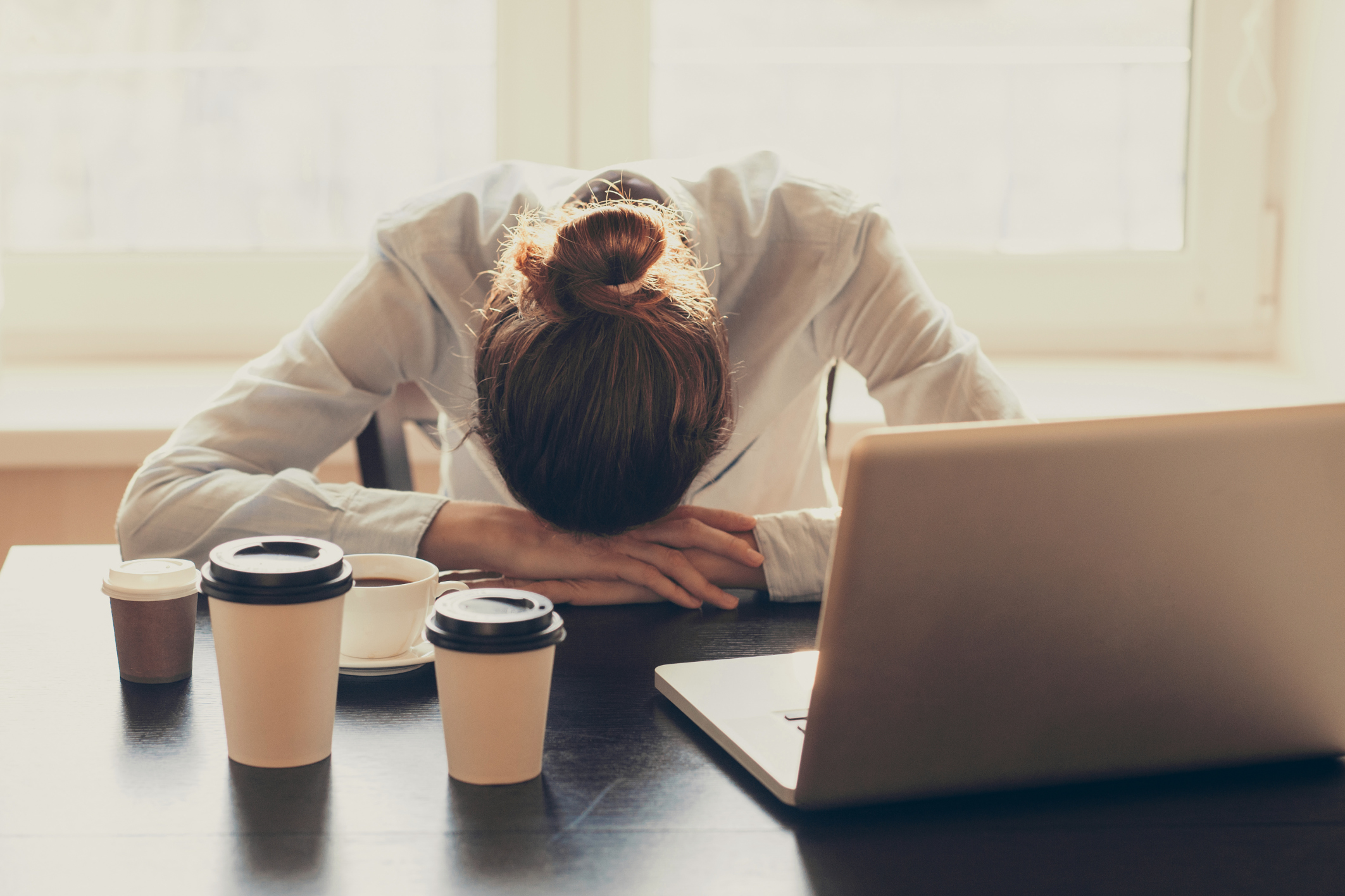 Woman with her head down at desk