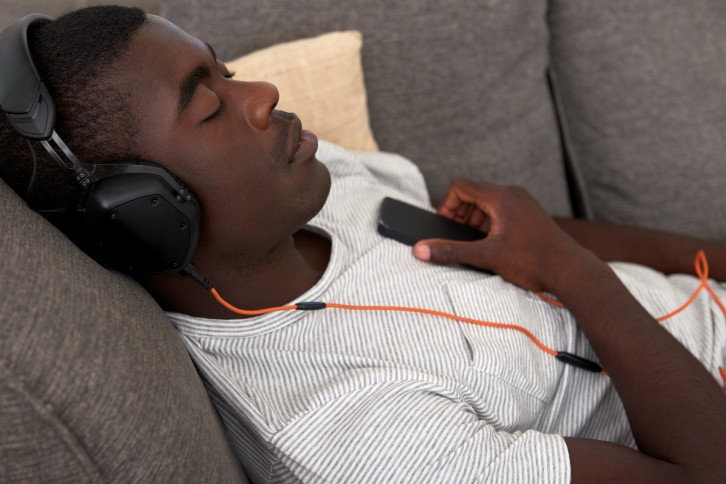 Young man wearing headphones takes a nap