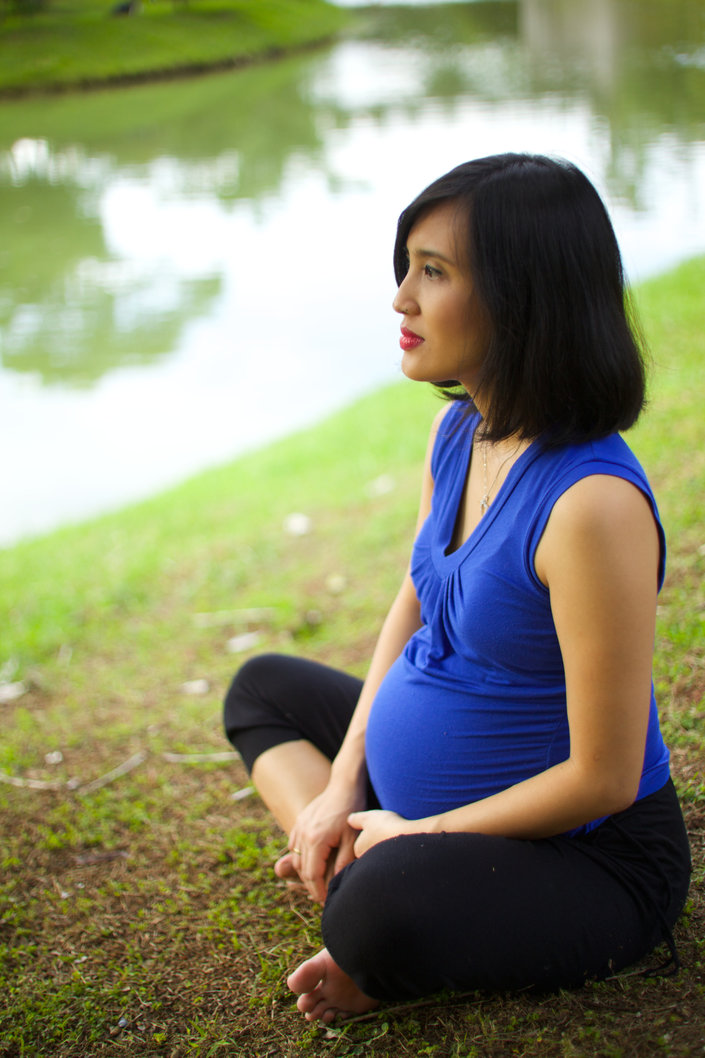 pregnant woman sitting outside on the grass