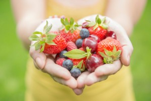 A girl's hands offer fruit