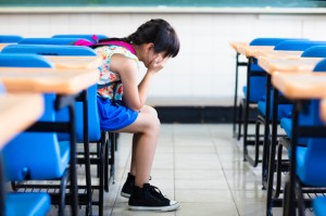 sad girl sitting and thinking in the classroom