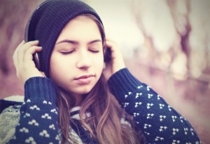 Teenage girl wearing headphones with eyes closed