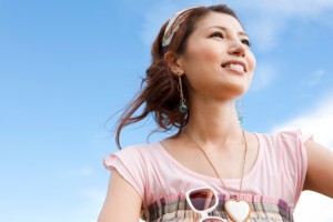 Young woman looking hopeful against blue sky