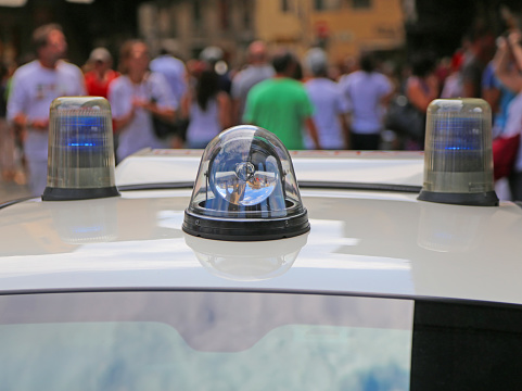 Police car lights in front of a crowd of people