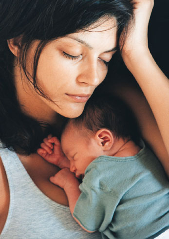 Exhausted mother sleeping with newborn