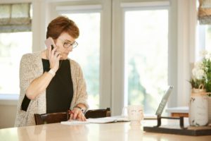 Therapist works on paperwork while talking on the phone.
