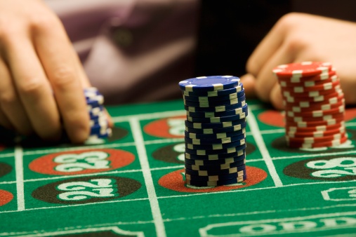 Gambling chips sitting on green felt table
