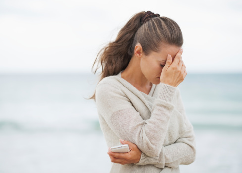 Woman standing on beach ...