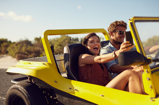 Happy couple taking selfie on road trip