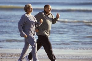 Two seniors walking on the beach together