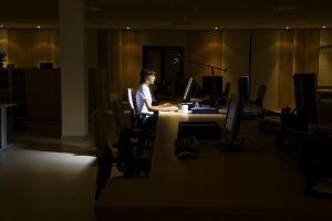Woman working late in dark office