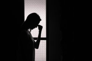 Silhouette of upset woman in open doorway