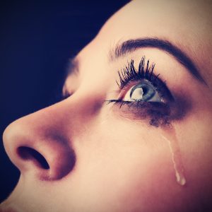 Closeup of tears streaming down woman's face