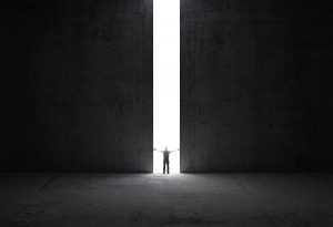 Man standing in light between walls