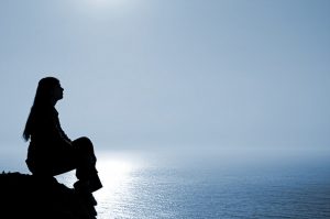 person on rock overlooking sea