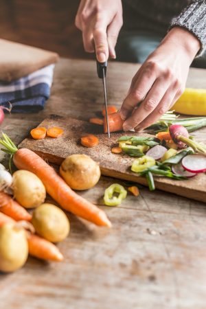 Hands chopping vegetables on counter