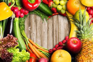 Fresh produce arranged on a wooden table in the shape of a heart