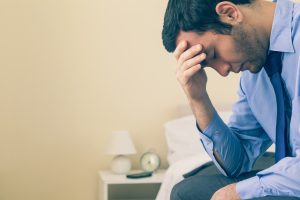 Depressed man sitting on his bed