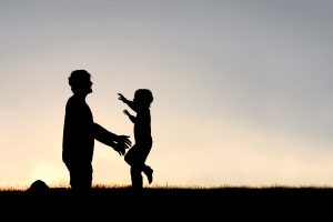 Silhouette of child running toward parent