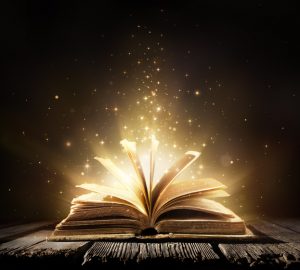 A book lies open on a table. shining lights come out of the pages