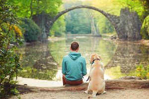 person with dog at pond