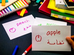 Hand holding flashcards for Arabic language