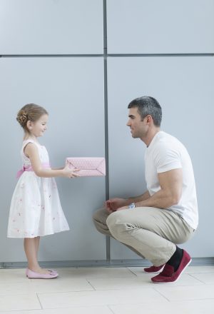 Child giving a gift to her father