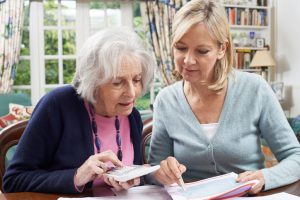 Mature woman helps elderly mother handle finances