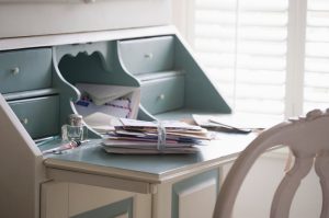 A stack of photos tied with ribbon on blue and white writing desk