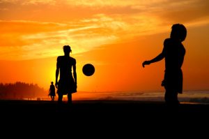 Playing footbal at the sunset on the beach