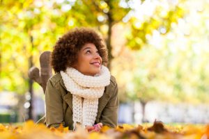 Person lying in autumn leaves outside