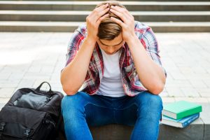 College student with head in hands