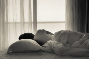 Woman laying in bed looking out window
