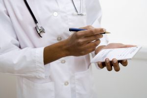 Doctor writing prescription for a patient