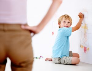 Boy caught by parent drawing on wall