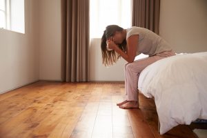 Woman crying in bedroom