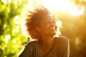 Woman smiling at the sun outside