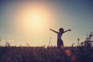 standing with arms outstretched in sunset field