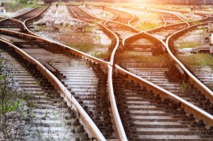 Sunlit view of train yard with several connected switching train tracks 