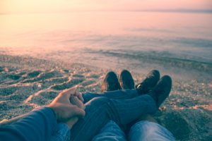 couple holding hands on beach