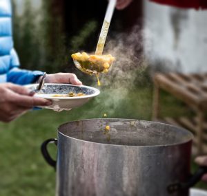ladling soup into bowl volunteer work