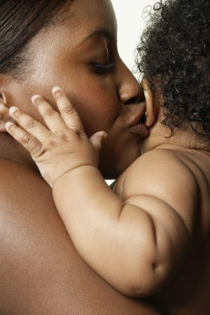 Mother holding and kissing baby