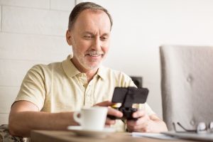 Older man smiles while playing video game