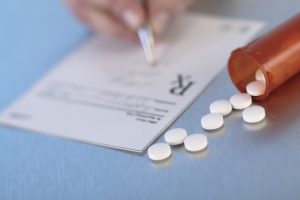 Pharmacist writing on prescription paper