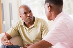 Father and son in living room talking about something serious