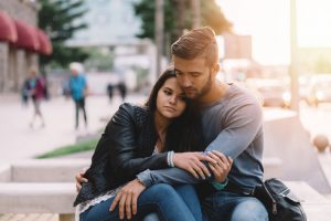 Man hugging woman outside