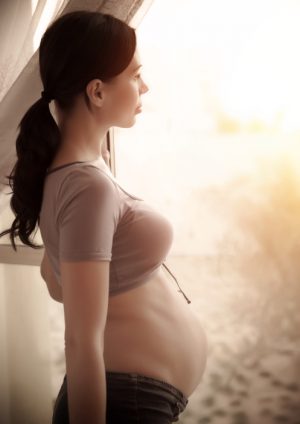 Pregnant woman looking out window