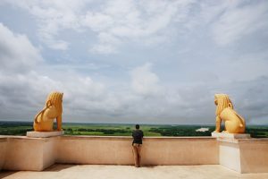Rear view of a man on terrace between two gold statues