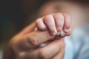 Newborn baby holding mother's hand