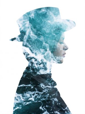 Double exposure of person wearing hat with calm face and eyes closed, turbulent sea